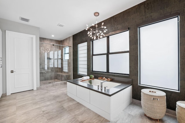 bathroom featuring a shower with door, a notable chandelier, plenty of natural light, and vanity