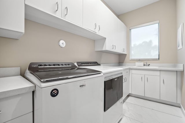 kitchen featuring white cabinetry and washing machine and clothes dryer