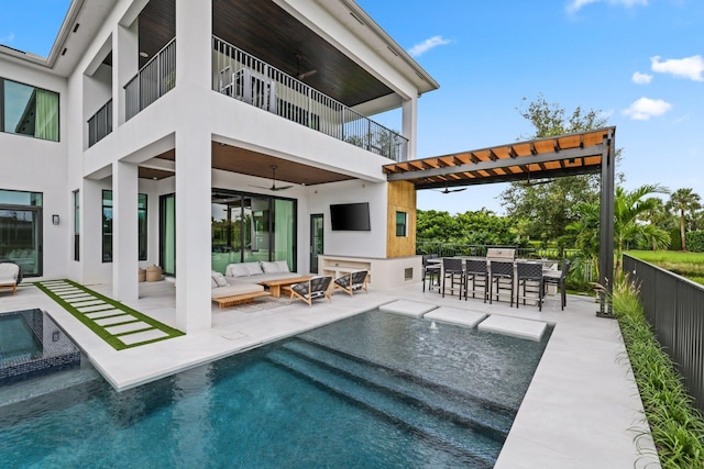 rear view of property with ceiling fan, an outdoor bar, a patio, outdoor lounge area, and a balcony