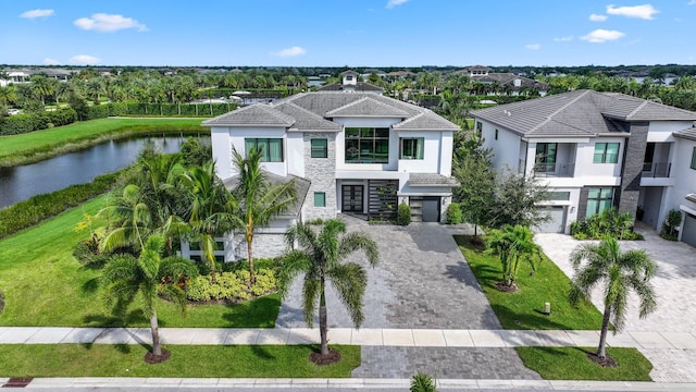 view of front of home featuring a front yard, a garage, and a water view