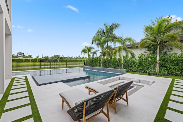 view of pool featuring a water view, a patio, and a jacuzzi