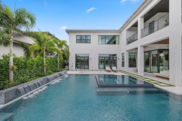 view of pool with an in ground hot tub, a patio area, and pool water feature