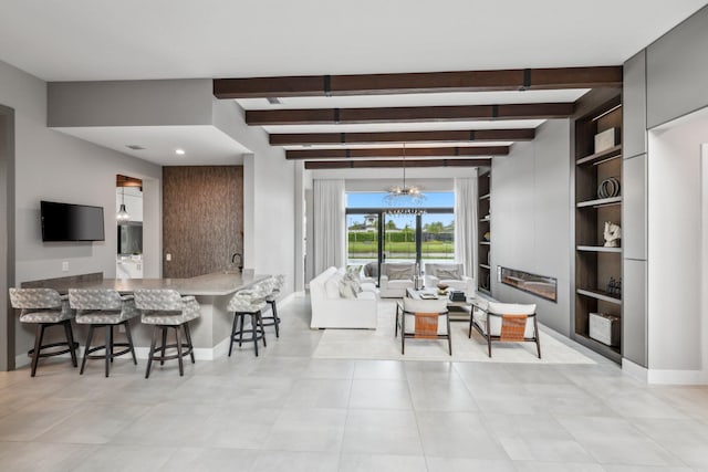 tiled living room with beam ceiling, built in features, and an inviting chandelier