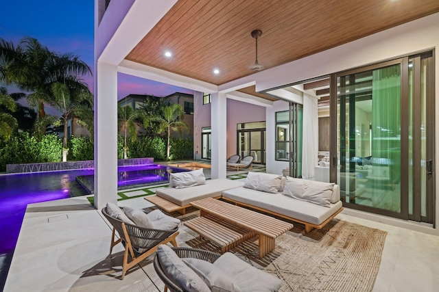 patio terrace at dusk with pool water feature and outdoor lounge area