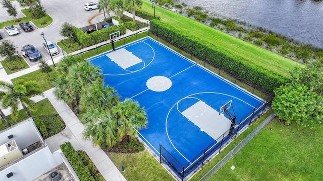 view of basketball court featuring a water view and a yard