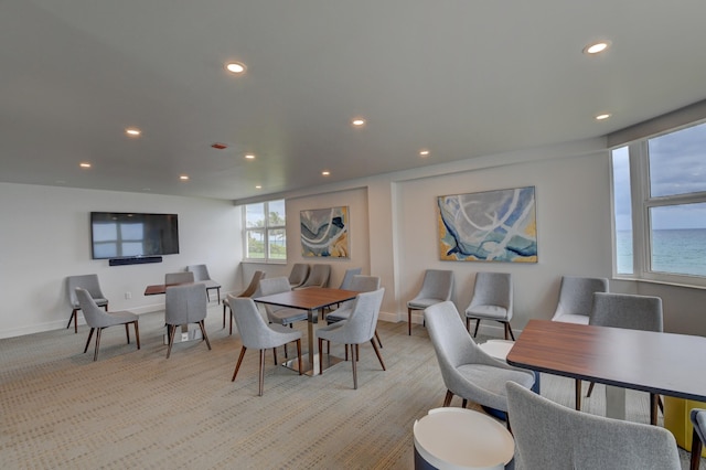 carpeted dining area featuring a water view