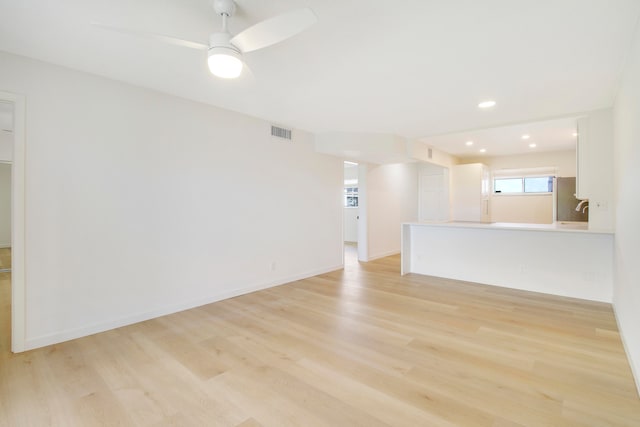 unfurnished living room featuring ceiling fan and light wood-type flooring