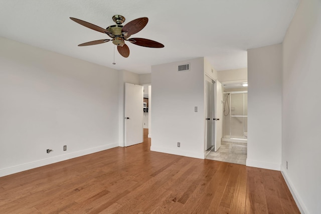 unfurnished bedroom with ensuite bathroom, ceiling fan, and light hardwood / wood-style flooring