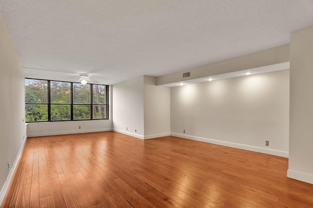 empty room featuring light hardwood / wood-style floors, a textured ceiling, and ceiling fan