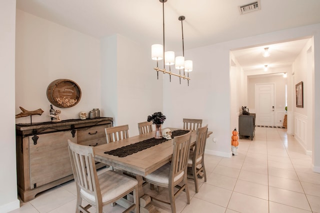 dining space with a chandelier and light tile patterned flooring