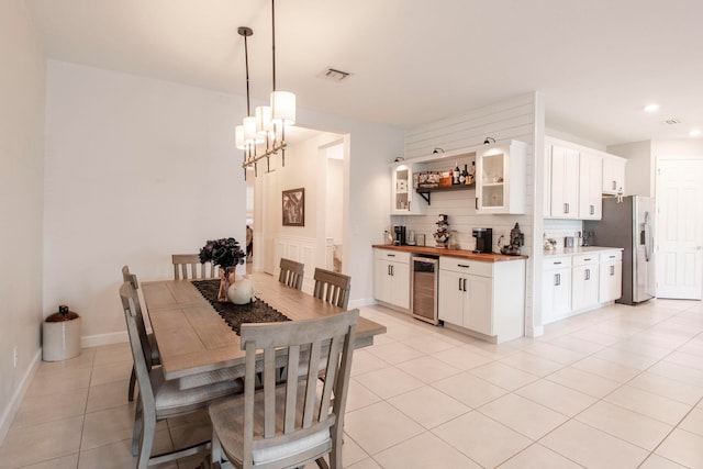 dining area with a notable chandelier, wine cooler, and light tile patterned floors