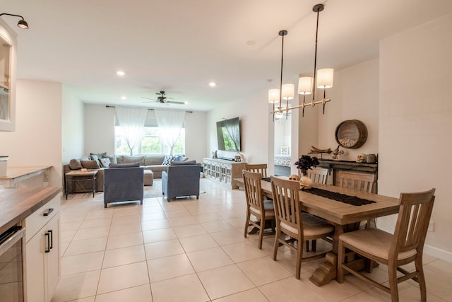 tiled dining area with ceiling fan with notable chandelier and beverage cooler