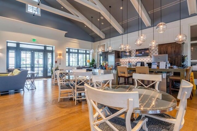 dining room with french doors, high vaulted ceiling, beamed ceiling, and light hardwood / wood-style flooring