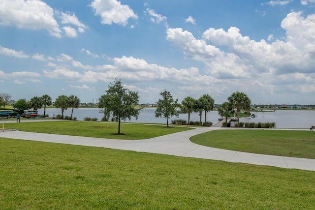 view of property's community with a yard and a water view