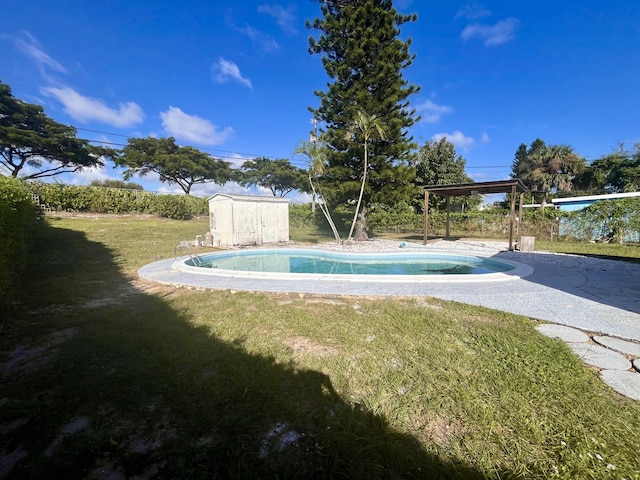 view of pool with a storage unit and a lawn