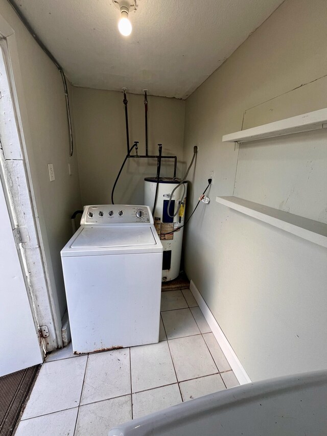 washroom featuring water heater, washer / clothes dryer, a textured ceiling, and light tile patterned flooring