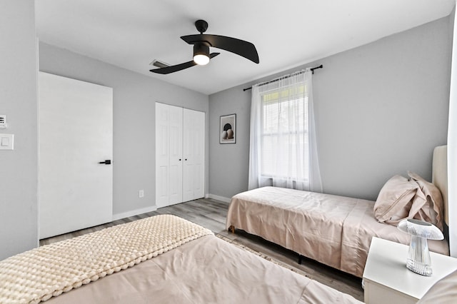 bedroom featuring ceiling fan, light hardwood / wood-style floors, and a closet