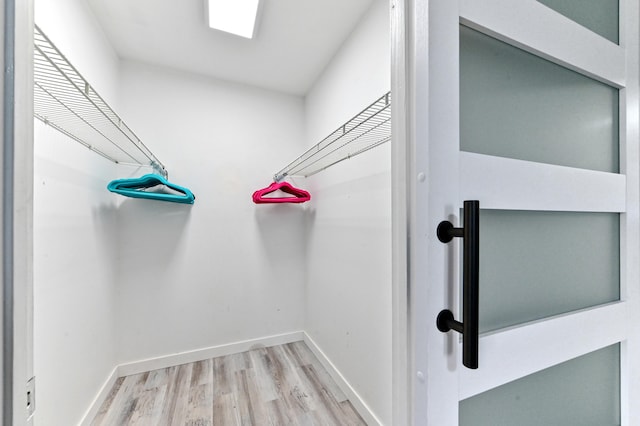 walk in closet featuring light hardwood / wood-style flooring