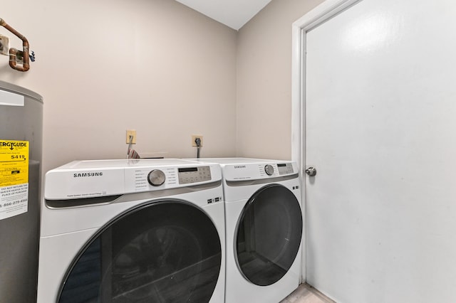 laundry area with electric water heater and washing machine and clothes dryer