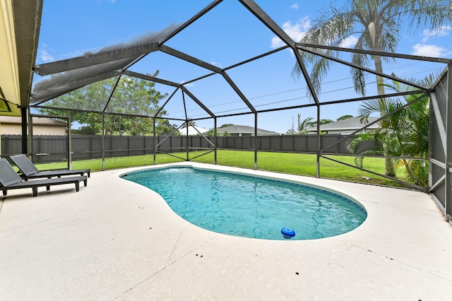 view of pool featuring a patio area, a yard, and glass enclosure