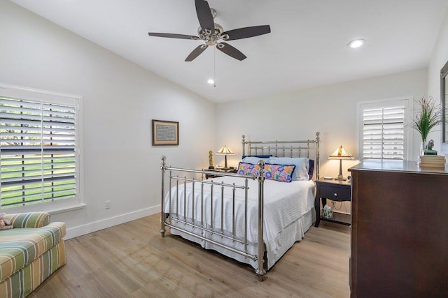 bedroom featuring light hardwood / wood-style flooring, lofted ceiling, multiple windows, and ceiling fan