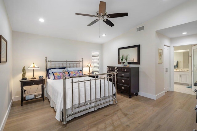 bedroom with light hardwood / wood-style floors, vaulted ceiling, ensuite bathroom, and ceiling fan