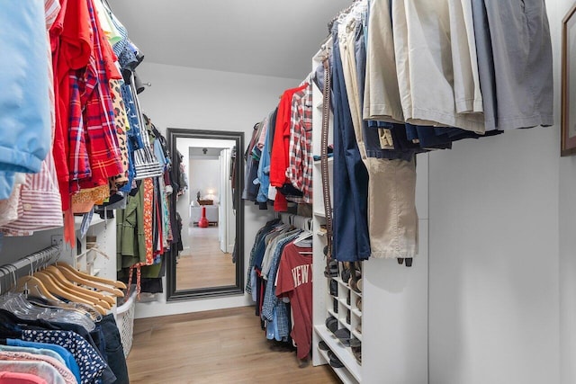 walk in closet with light hardwood / wood-style flooring