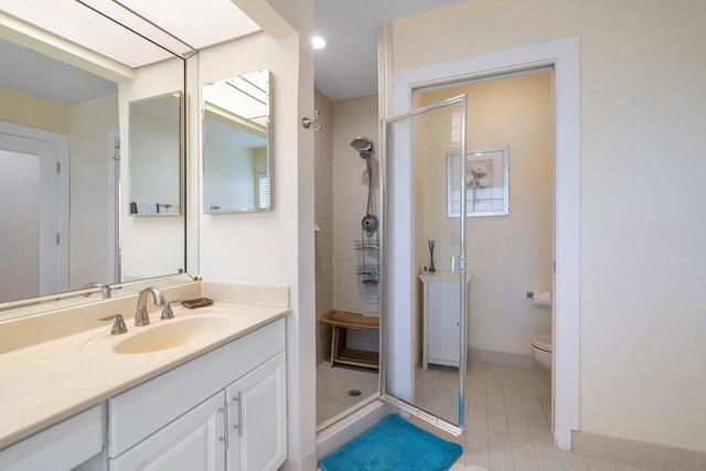 bathroom with vanity, toilet, walk in shower, and tile patterned flooring