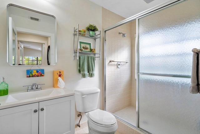 bathroom featuring toilet, an enclosed shower, vanity, and tile patterned flooring