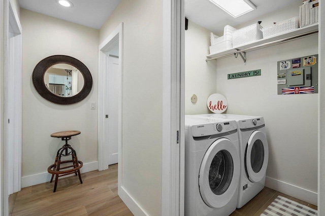 laundry room featuring independent washer and dryer and light wood-type flooring