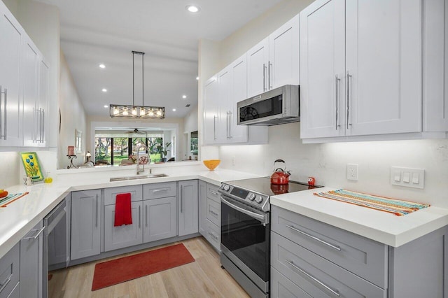 kitchen featuring gray cabinetry, light hardwood / wood-style flooring, stainless steel appliances, and sink