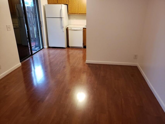 kitchen with a wealth of natural light, white appliances, and dark hardwood / wood-style flooring