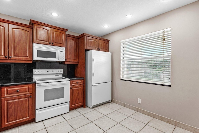 kitchen with tasteful backsplash, light tile patterned floors, a textured ceiling, and white appliances