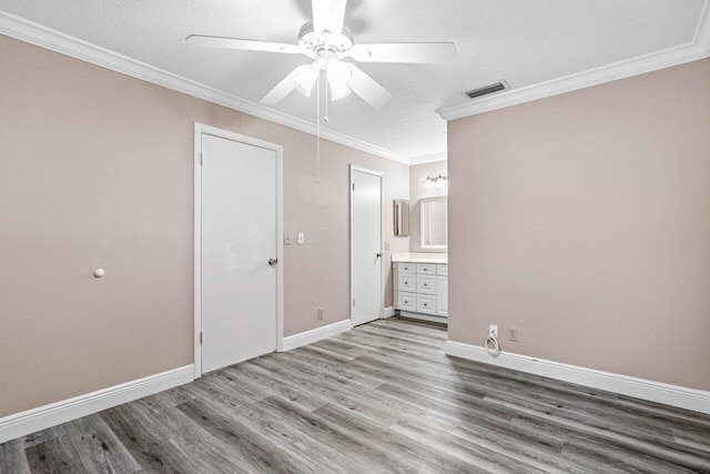 spare room featuring hardwood / wood-style flooring, ornamental molding, and a textured ceiling