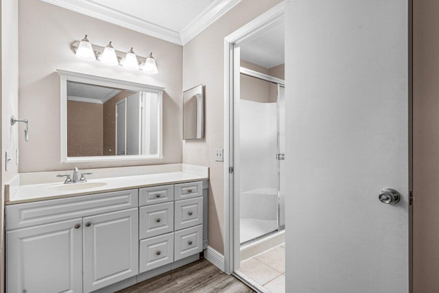 bathroom featuring vanity, hardwood / wood-style floors, crown molding, and a shower with door