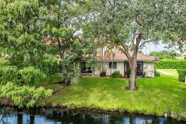 view of front facade with a water view and a front lawn