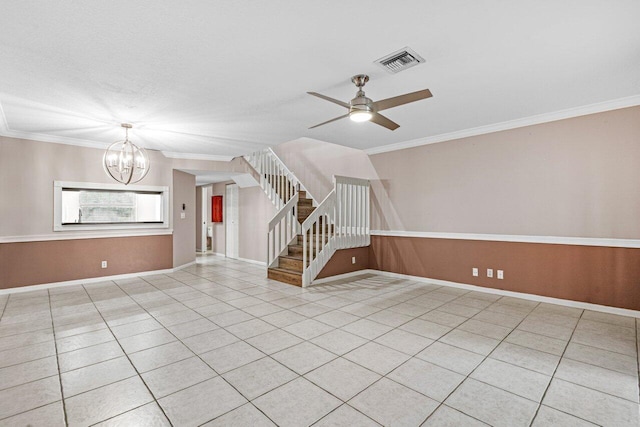 tiled empty room with ceiling fan with notable chandelier and ornamental molding