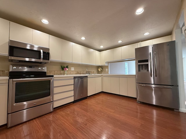 kitchen with white cabinets, sink, light wood-type flooring, and stainless steel appliances