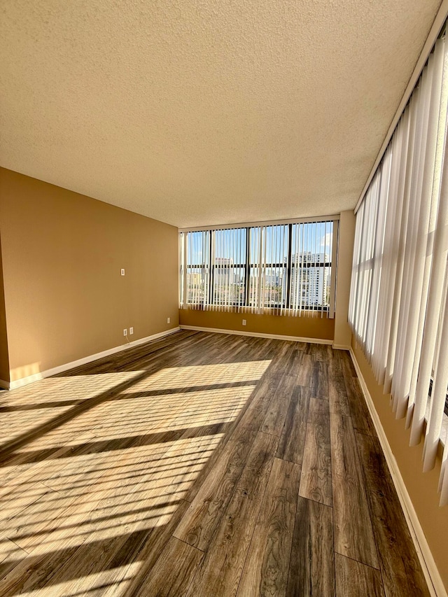 spare room featuring wood-type flooring and a textured ceiling