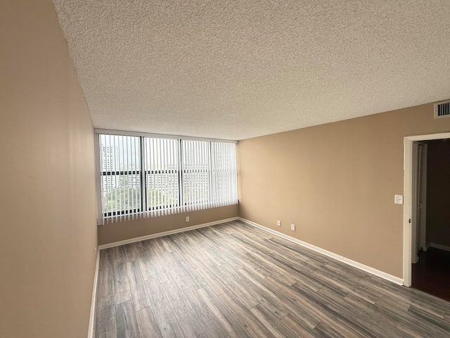 unfurnished room featuring wood-type flooring and a textured ceiling