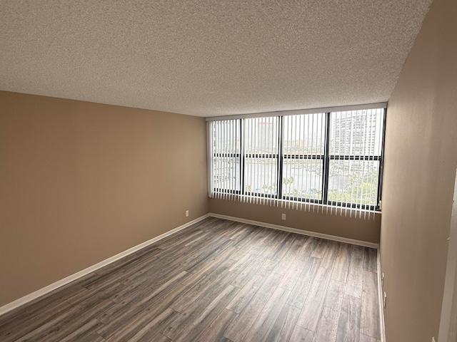 empty room with a textured ceiling and hardwood / wood-style flooring