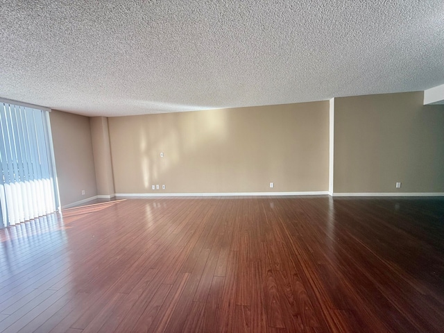 empty room with hardwood / wood-style floors and a textured ceiling