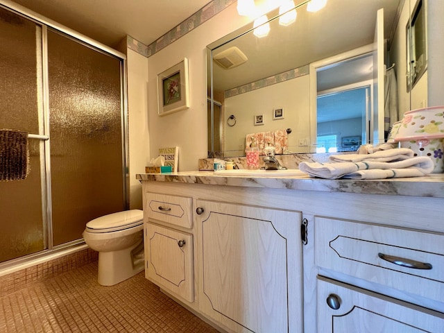 bathroom with vanity, a shower with shower door, and toilet