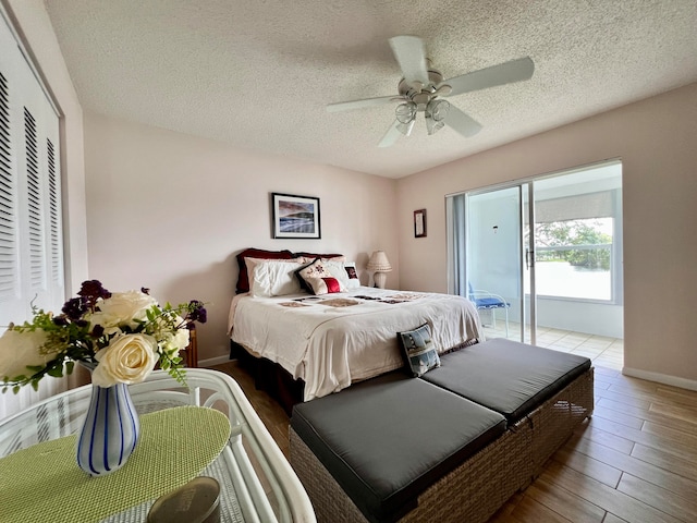 bedroom with a closet, a textured ceiling, light wood-type flooring, and ceiling fan