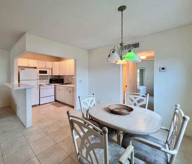 dining space featuring sink, a chandelier, and light tile patterned flooring