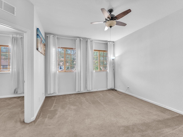 carpeted spare room featuring ceiling fan