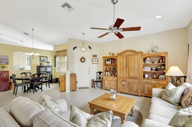 living room featuring lofted ceiling and ceiling fan with notable chandelier