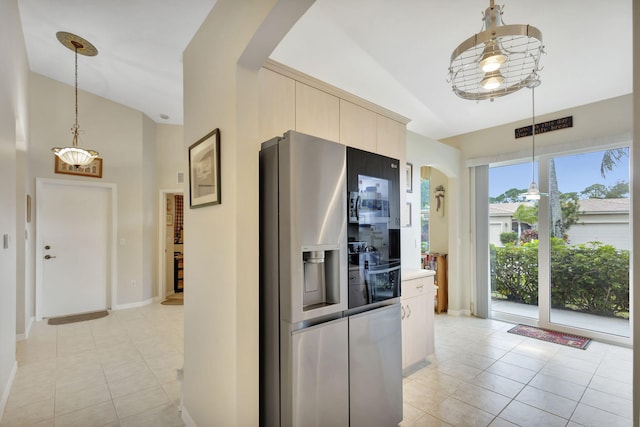 kitchen with vaulted ceiling, decorative light fixtures, and stainless steel fridge