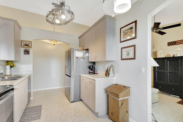 kitchen featuring light brown cabinets, ceiling fan, appliances with stainless steel finishes, light tile patterned flooring, and sink