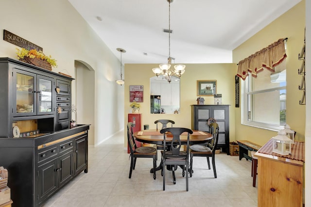 tiled dining area featuring lofted ceiling and a notable chandelier